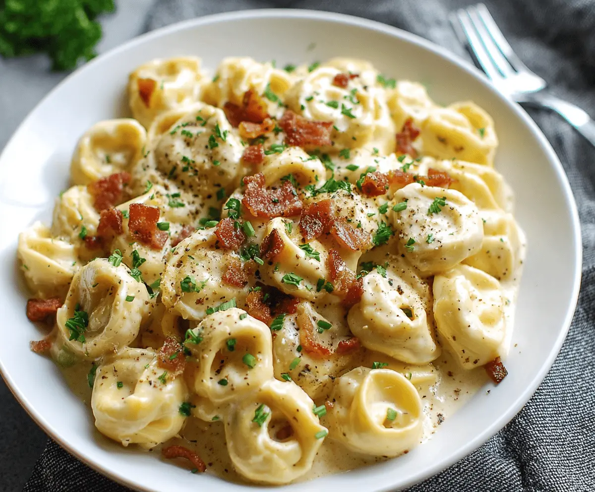 Creamy tortellini carbonara served in a white bowl with grated cheese and fresh herbs, highlighting a delicious Italian pasta dish