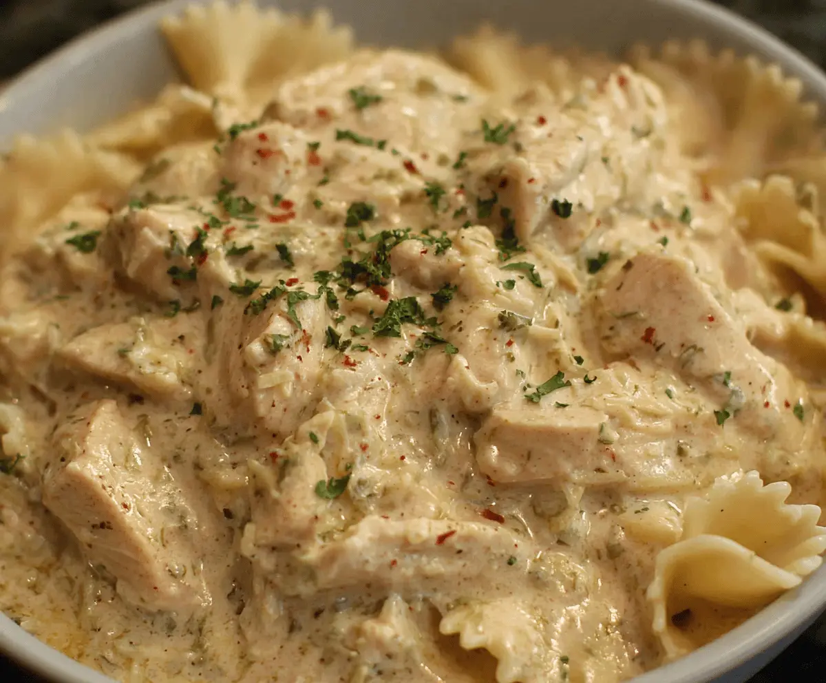 Creamy Ranch Chicken cooked in a Crockpot, featuring tender shredded chicken in a flavorful ranch sauce, served with fresh herbs and side dishes.