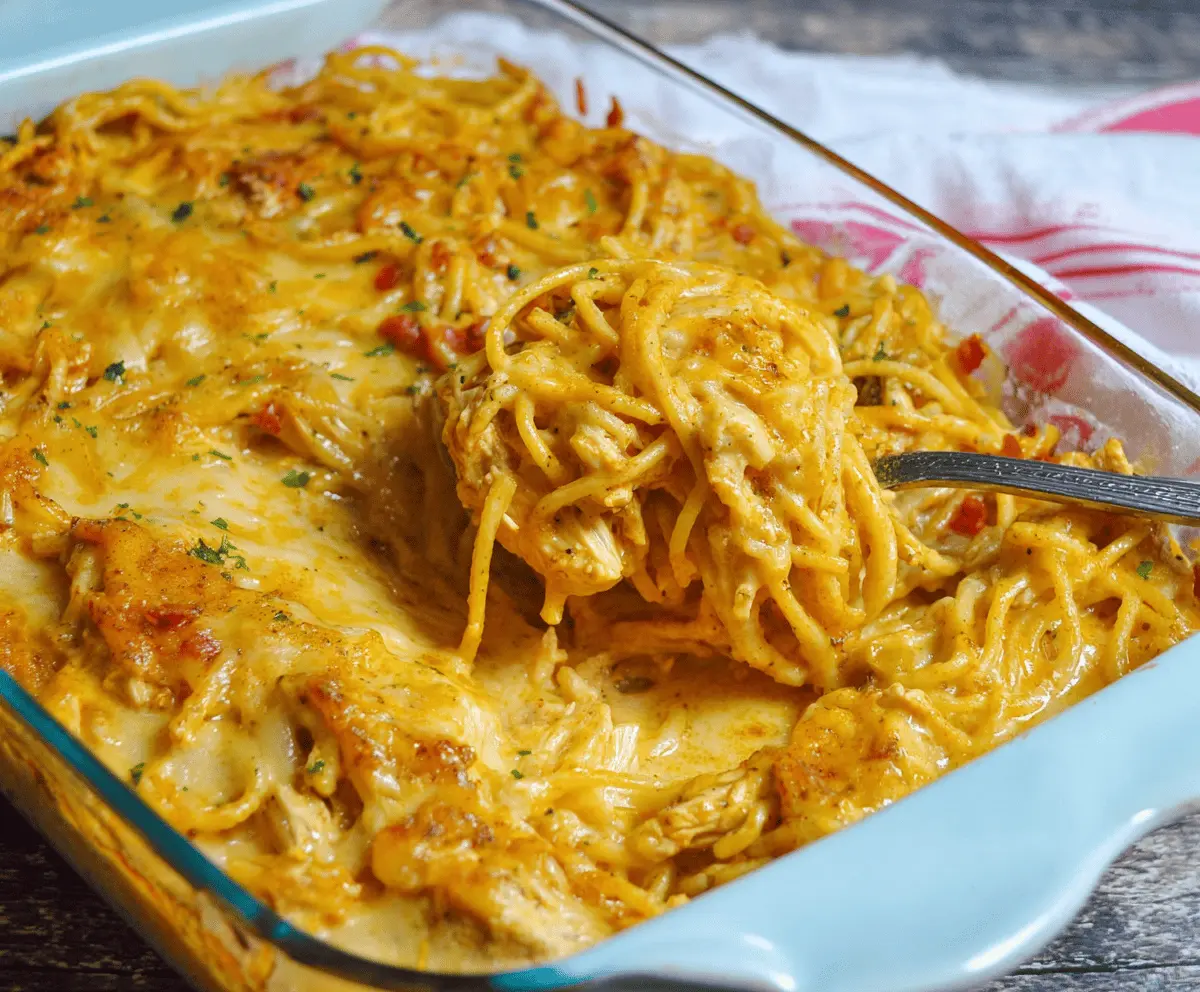 Creamy and spicy Southern chicken spaghetti casserole topped with melted cheese and fresh herbs, perfect for a comforting dinner