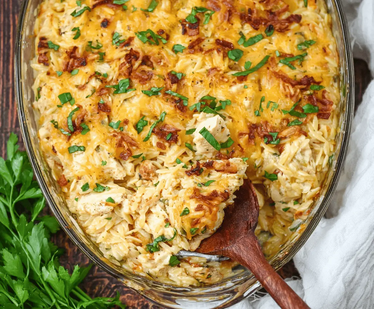 Creamy French Onion Chicken Orzo Casserole topped with melted cheese and caramelized onions, served in a baking dish