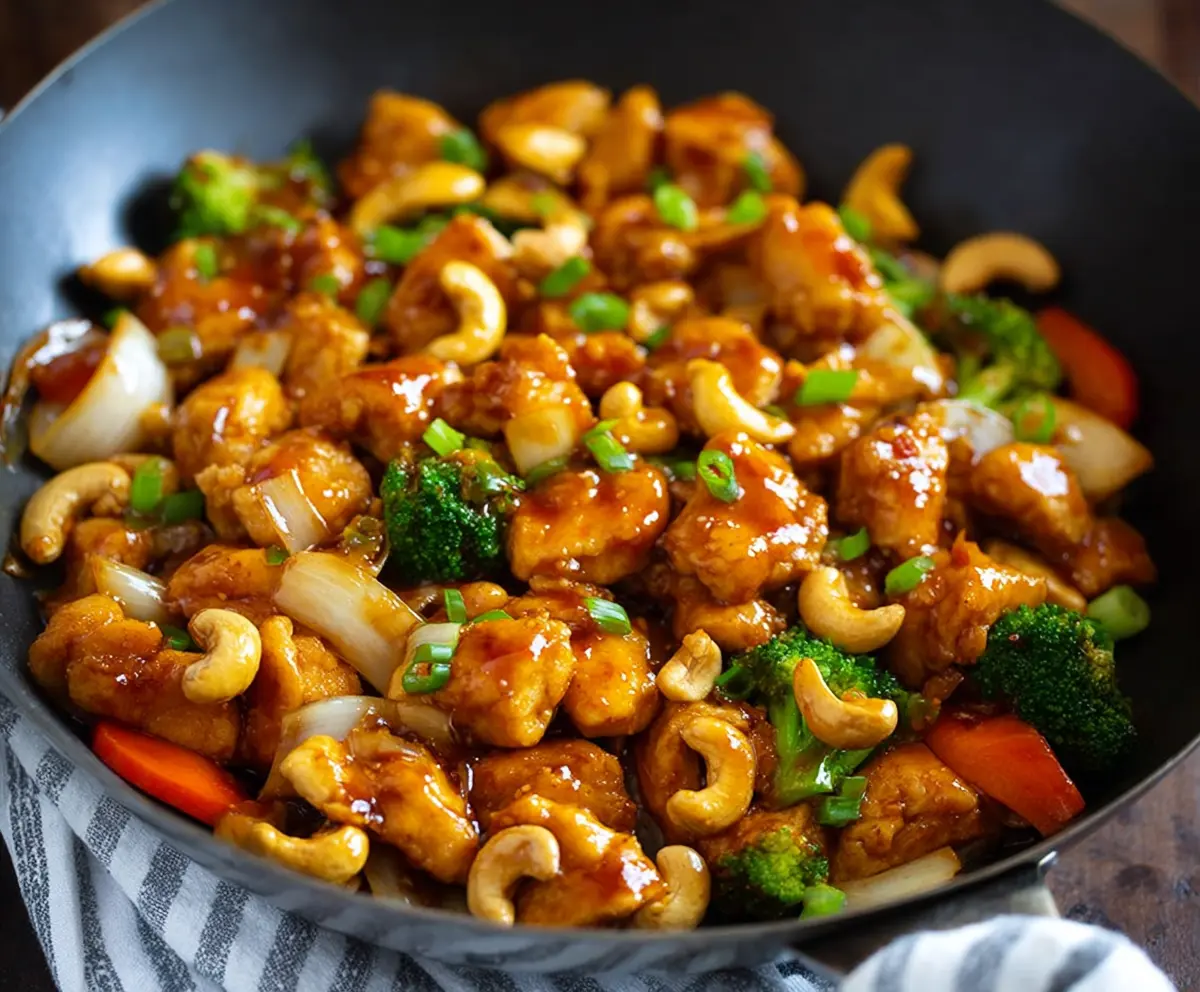 Delicious Easy Authentic Cashew Chicken served on a plate with fresh vegetables and rice.