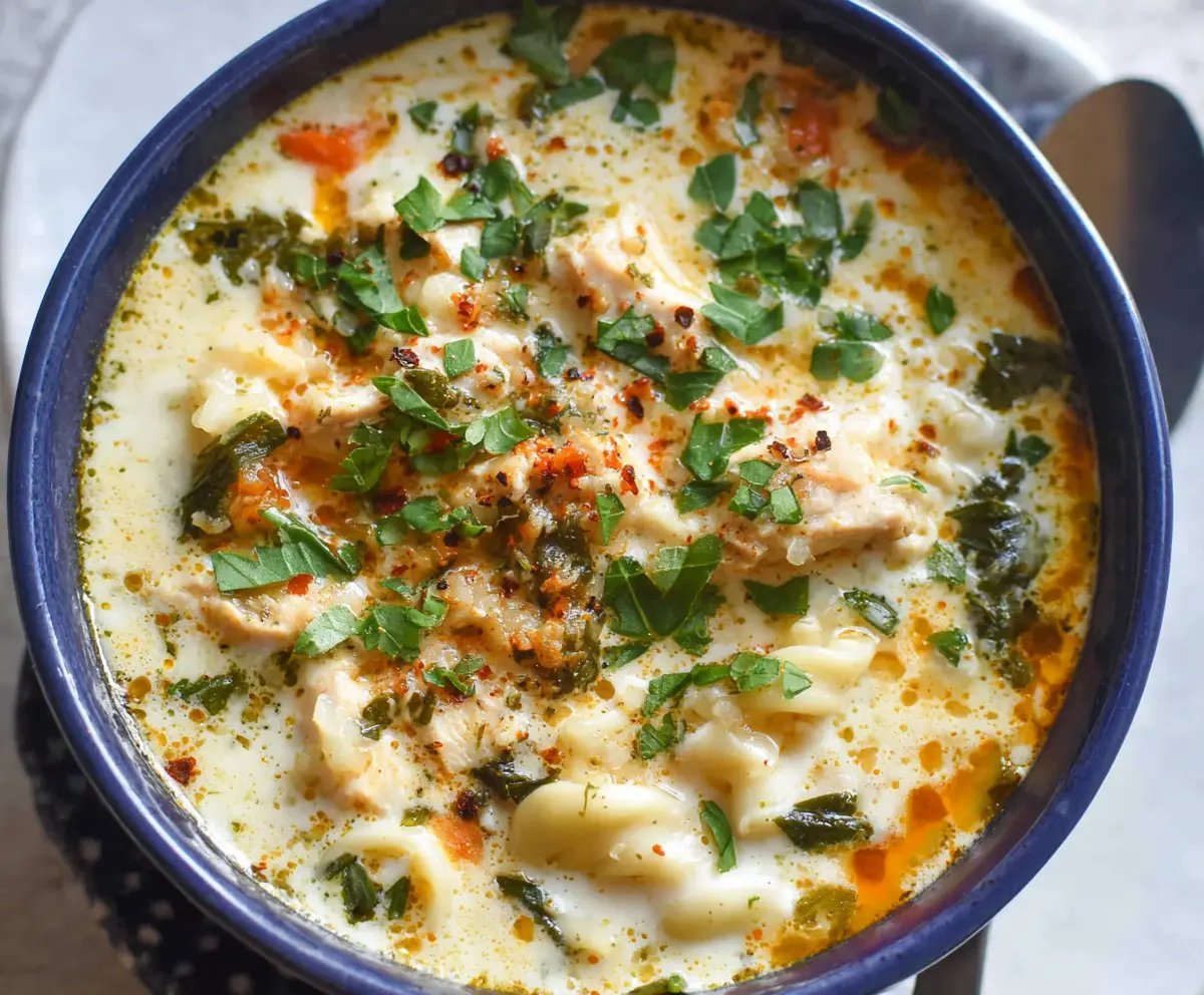 Creamy white lasagna soup garnished with herbs in a bowl, perfect for cozy dinners.